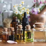 A picture of oils, mortar and pestle, flowers, herbs and resin.