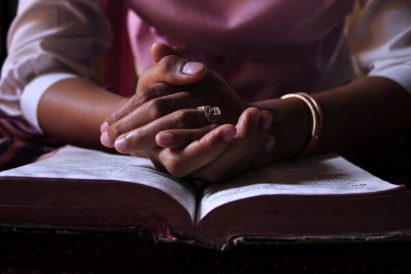 A picture of woman praying over scripture.